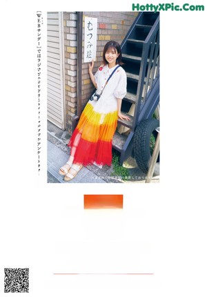 A woman in a colorful skirt is dancing on the street.