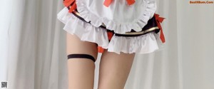 A woman with pink hair wearing a maid outfit.