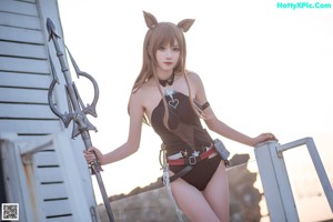 A woman in a cat costume sitting on a wooden dock.