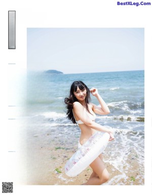 A woman in a white bikini holding a beach ball.
