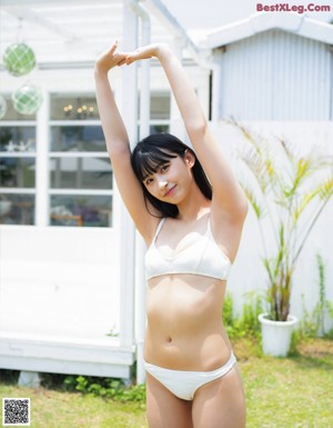 A woman in a white bikini holding a beach ball.