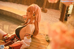 A woman sitting on a wooden bench holding a cup of coffee.