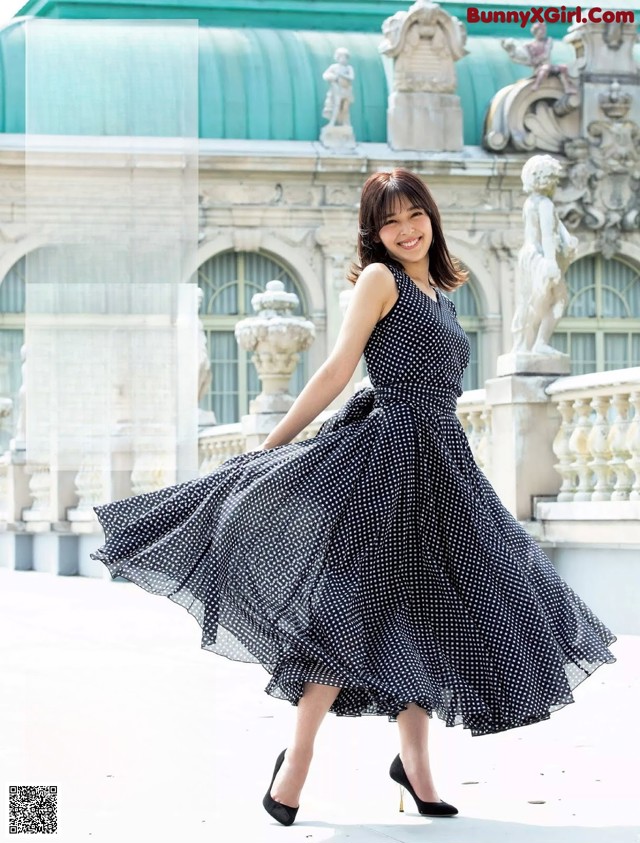 A woman in a black and white polka dot dress.