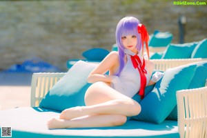 A woman in a white bathing suit sitting by a swimming pool.