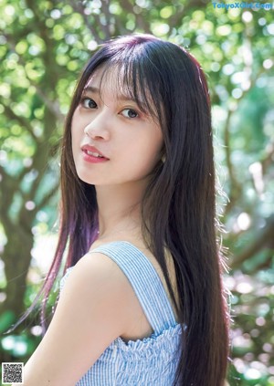 A woman with long black hair wearing a blue and white dress.