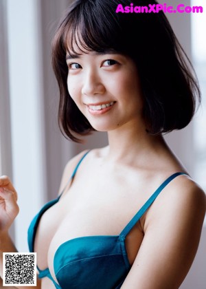 A woman in a black bikini sitting on a brown chair.
