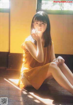 A woman with black hair and bangs is posing for a magazine.