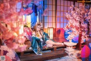 A woman in a blue and green kimono posing for a picture.
