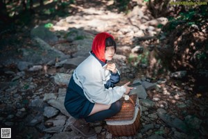 A woman in a red hoodie is posing for a picture.