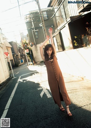 A woman standing in front of a red door.