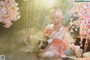 A woman in a kimono sitting on a wooden bench.