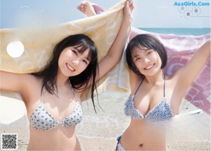 Two women in white bikinis standing next to each other.