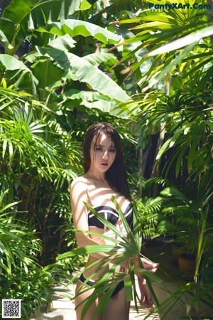 A woman in a black and white bikini posing for a picture.