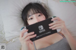 A woman in a bikini playing a video game on a Nintendo Switch.