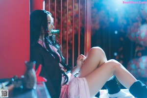 A woman in a pink kimono laying on the floor.