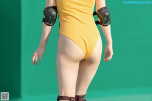 A woman in a yellow swimsuit posing for a picture.
