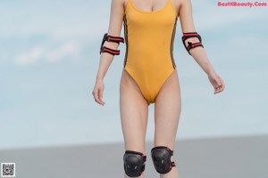 A woman in a yellow swimsuit posing for a picture.