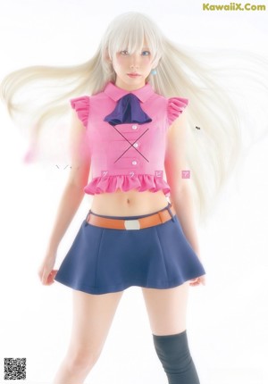 A woman in a pink shirt and blue skirt holding a stuffed animal.