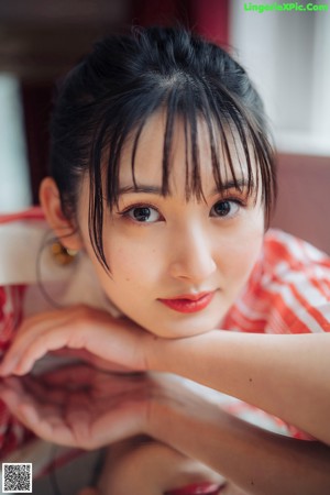 A woman wearing a red and white striped shirt and a pair of earrings.