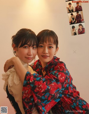 A couple of women sitting next to each other on a red chair.