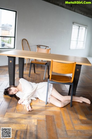 A woman laying on top of a white couch.
