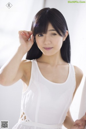 A woman in a white lingerie leaning against a wall.