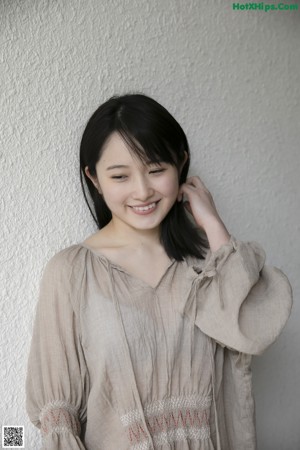 A woman standing in front of a black door.