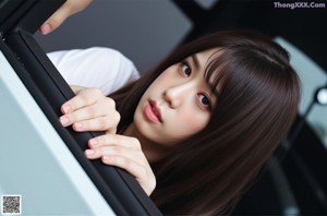 a woman with long black hair wearing a pink shirt