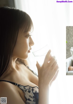 A woman sitting on a couch holding a bunch of flowers.