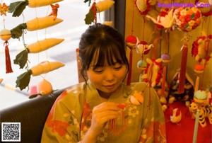 A woman in a kimono sitting by a window.