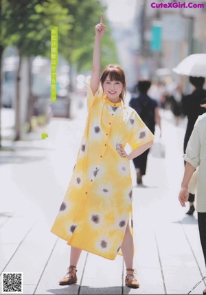 A woman in a yellow dress posing for a magazine.