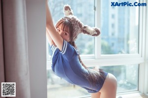A woman in a bunny costume sitting on a window sill.