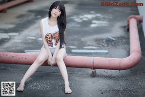 A woman in an orange bikini sitting on a chair.