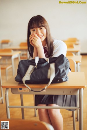 A young woman holding a leaf in her hand.