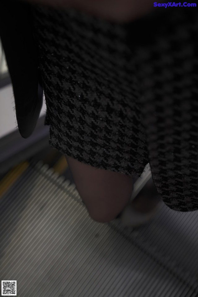 A close up of a person's legs on an escalator.