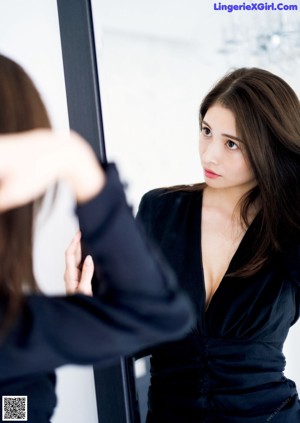 A woman in a black lingerie posing on a bed.