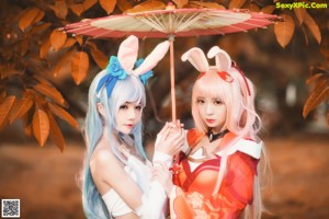 A couple of women dressed in costumes standing next to each other.